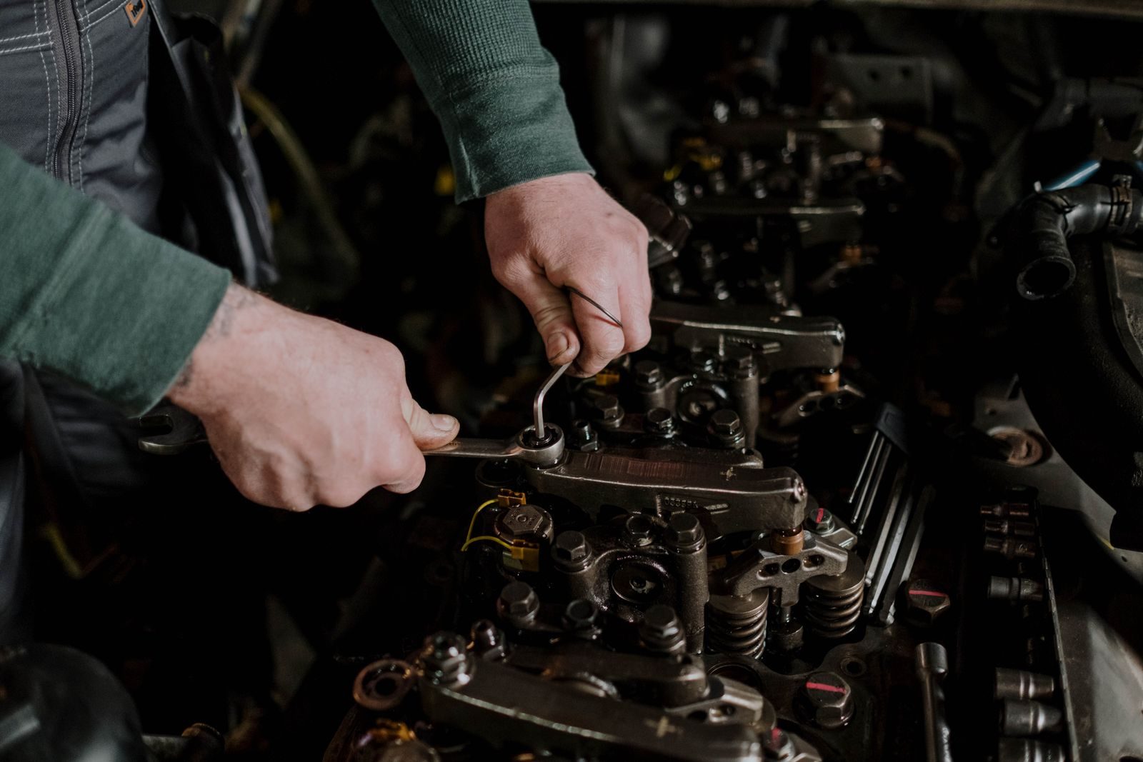 Mains de mécanicien avec outils sur un moteur