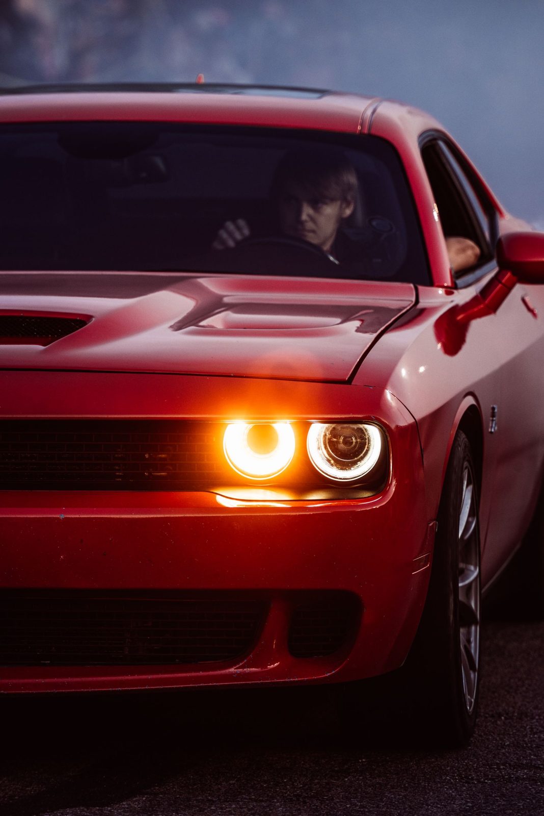 Voiture rouge phares allumés la nuit